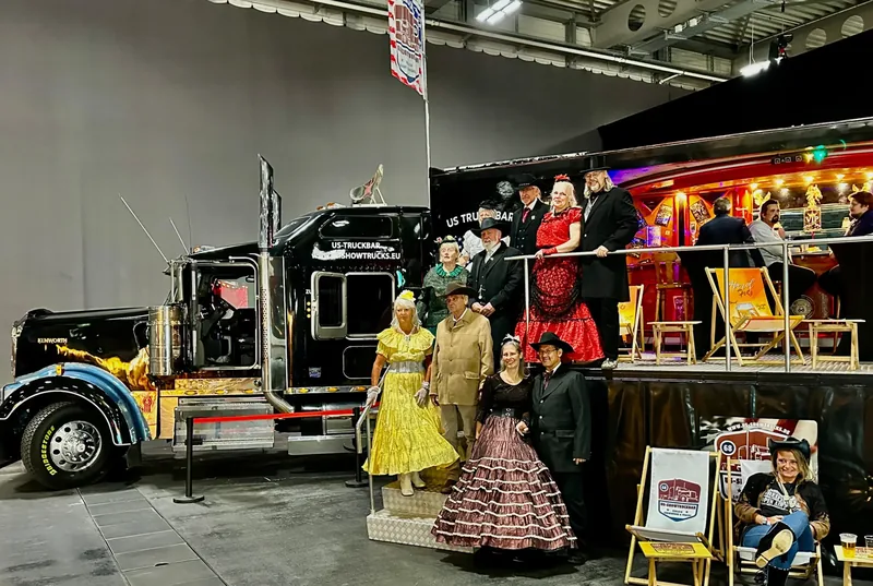 Der schwarze Kenworth in der Messehalle Erfurt neben historischen Kostümen
