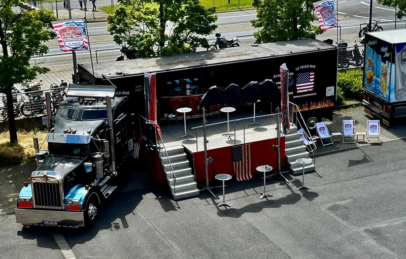 Der schwarze Showtruck mit ausgeklappter Bar und Stehtischen
