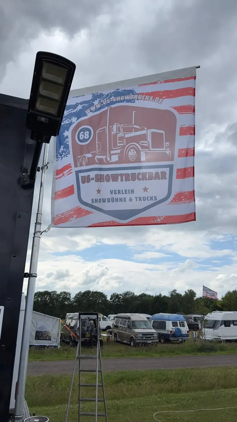 Fahne mit dem US-Showtruckbar-Logo über dem Veranstaltungsgelände
