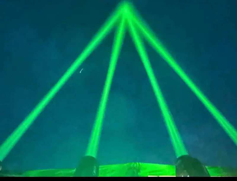 Grüne Laserstrahlen der Lichtshow über dem Nachthimmel