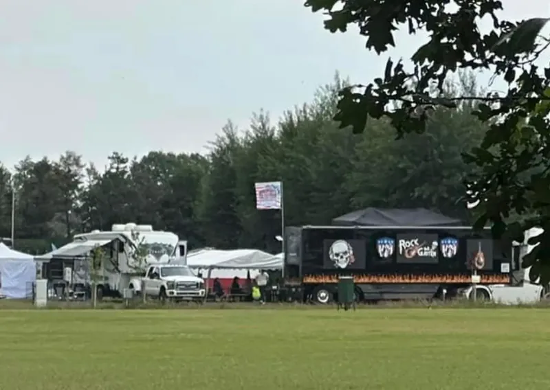 Der Showtruck steht am Rand der Festwiese zwischen Bäumen