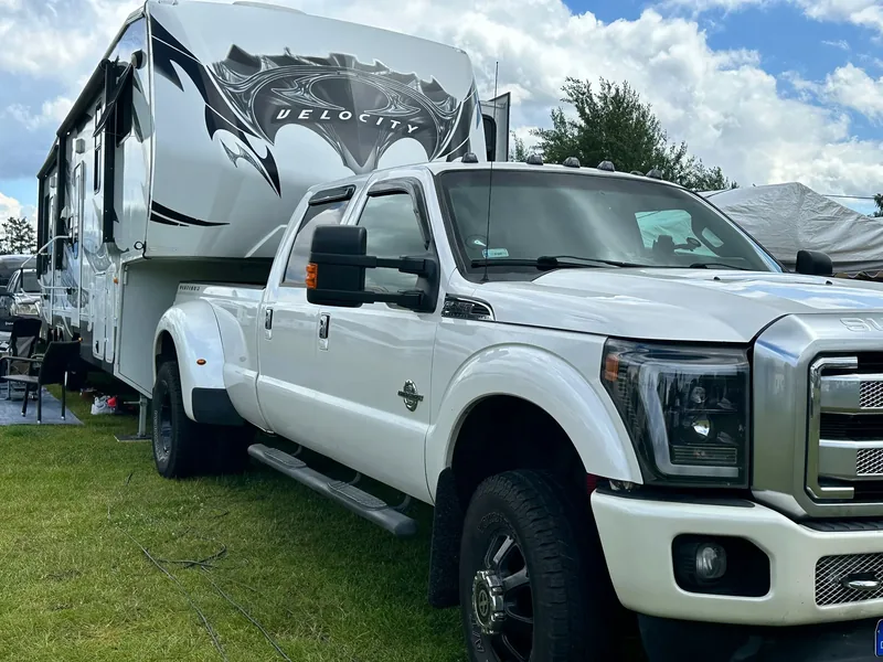 Weißer US-Pick-up vor einem großen Motorhome