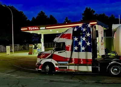 Beleuchtete Zugmaschine mit US-Flaggen-Lackierung an einer Tankstelle