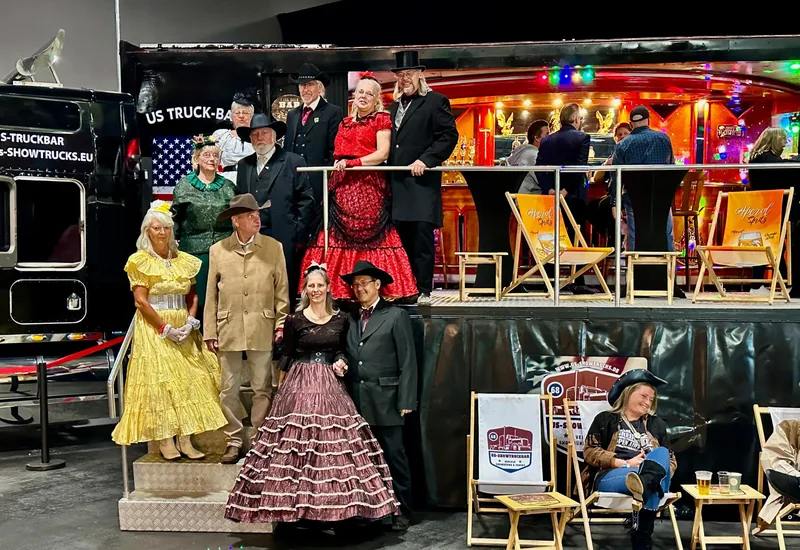 Standbesetzung in historischen Kostümen vor dem Showtruck