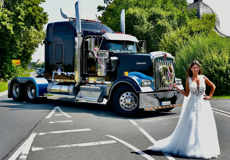 Braut im weißen Kleid vor dem blauen Kenworth W900