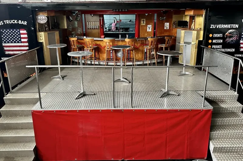 Innenraum der US Truck-Bar mit roter Theke, Barhockern und US-Flagge