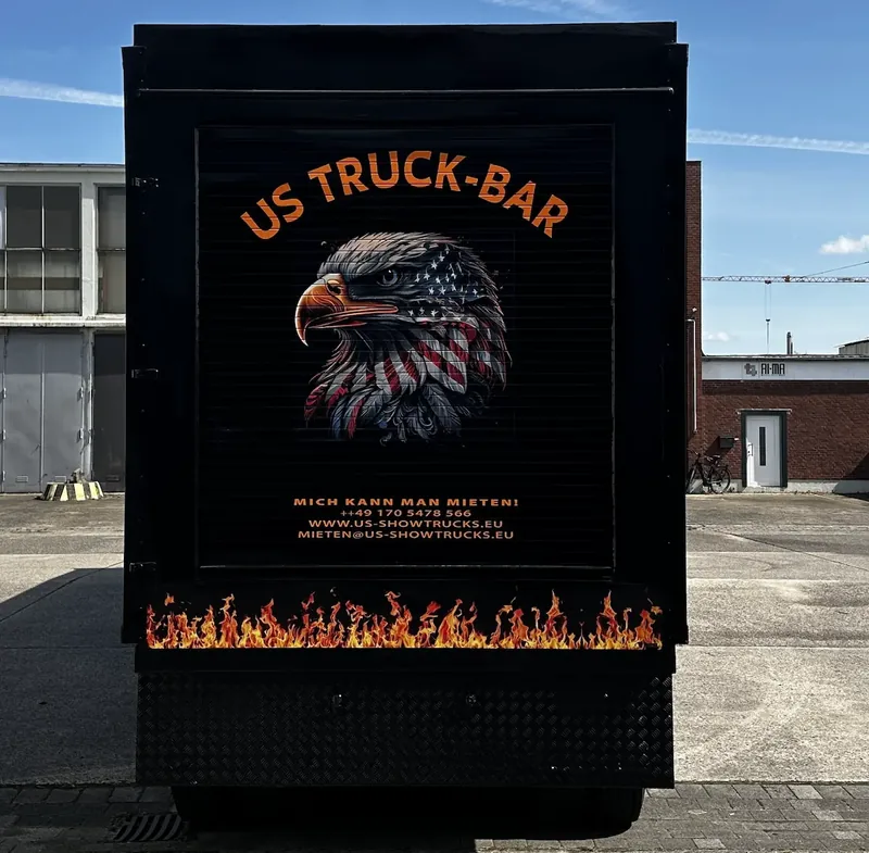 Werbetafel „US Truck-Bar“ mit Adlermotiv an der Trailerwand